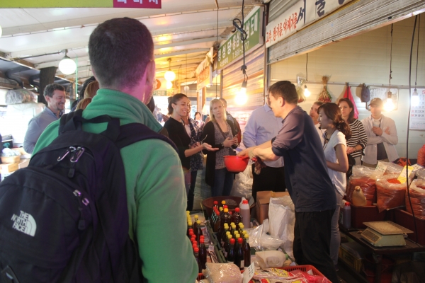 오미요리 연구소 프로그램에 참가해 전통시장에서 직접 장을 보며 상인과 대화를 나누고 있는 외국인 참가자들의 모습 [사진=부천중동시장 제공]